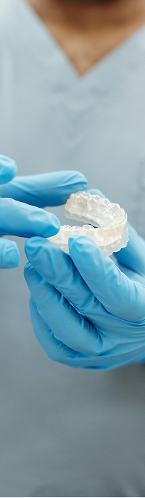 Dentist holding a clear aligner